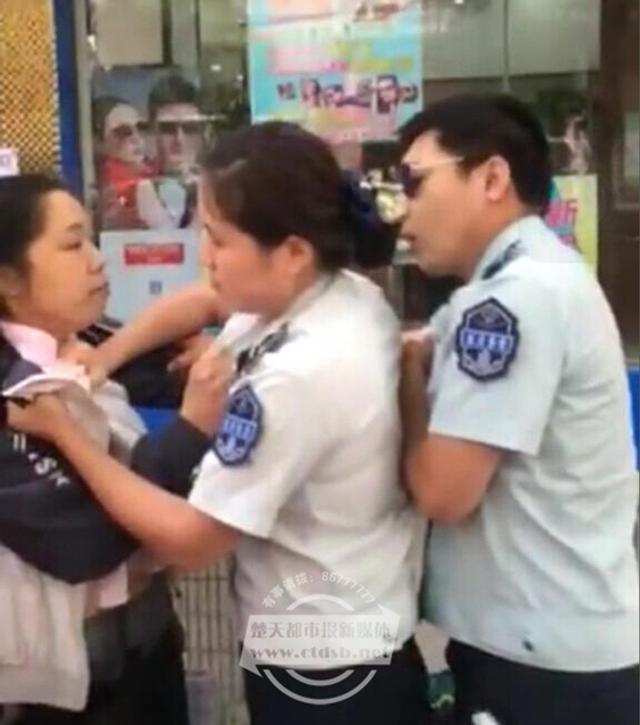 女摊贩紧拽城管大腿
