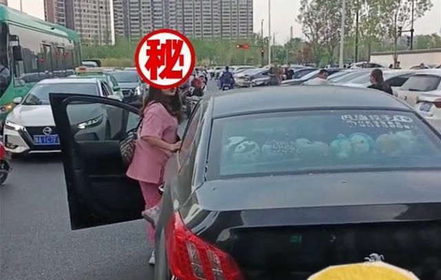 路上堵车女子突然从豪车中探出身体